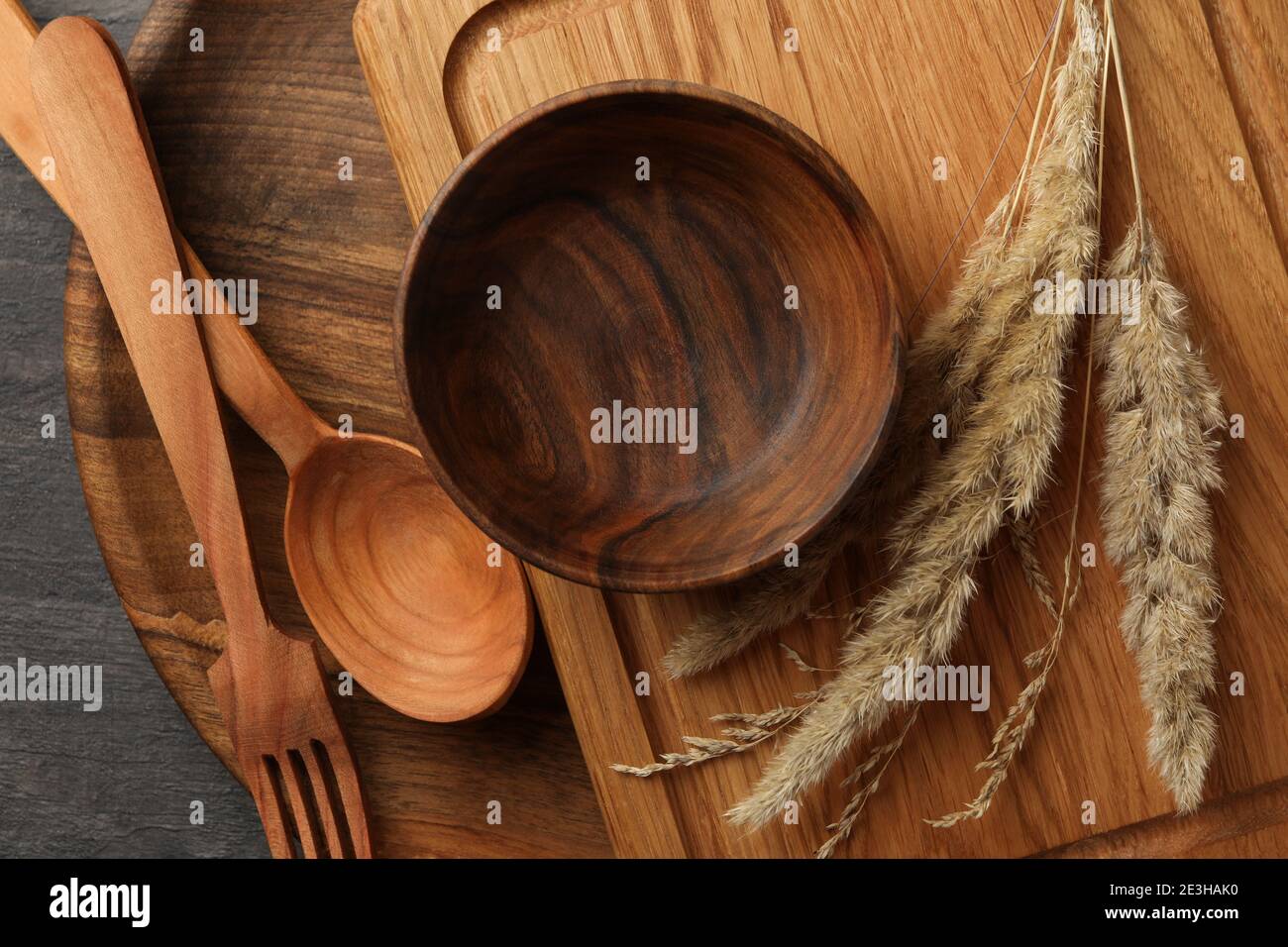 Different wooden kitchenware on dark table, top view Stock Photo - Alamy