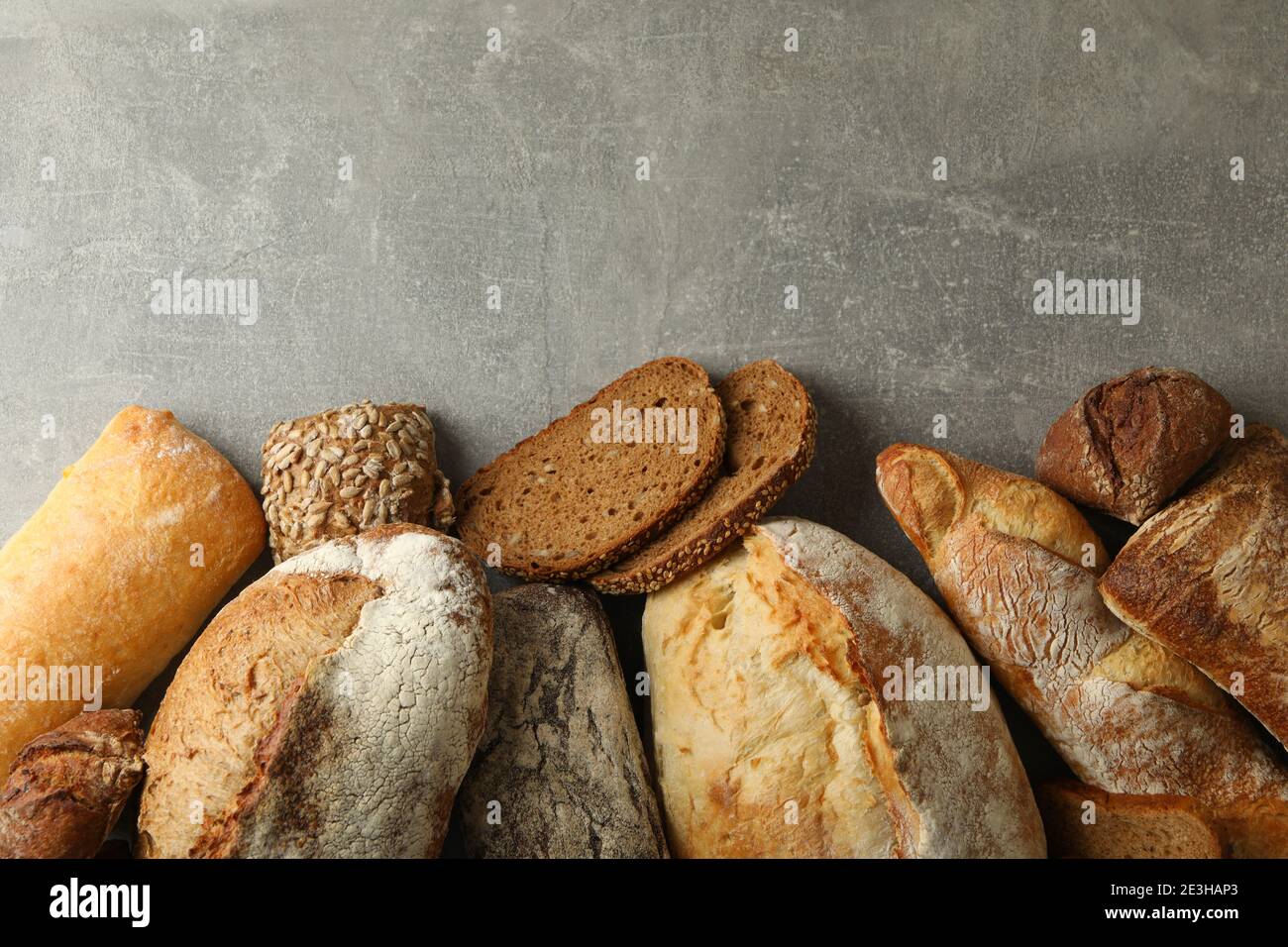 Different fresh baked bread on gray background Stock Photo - Alamy