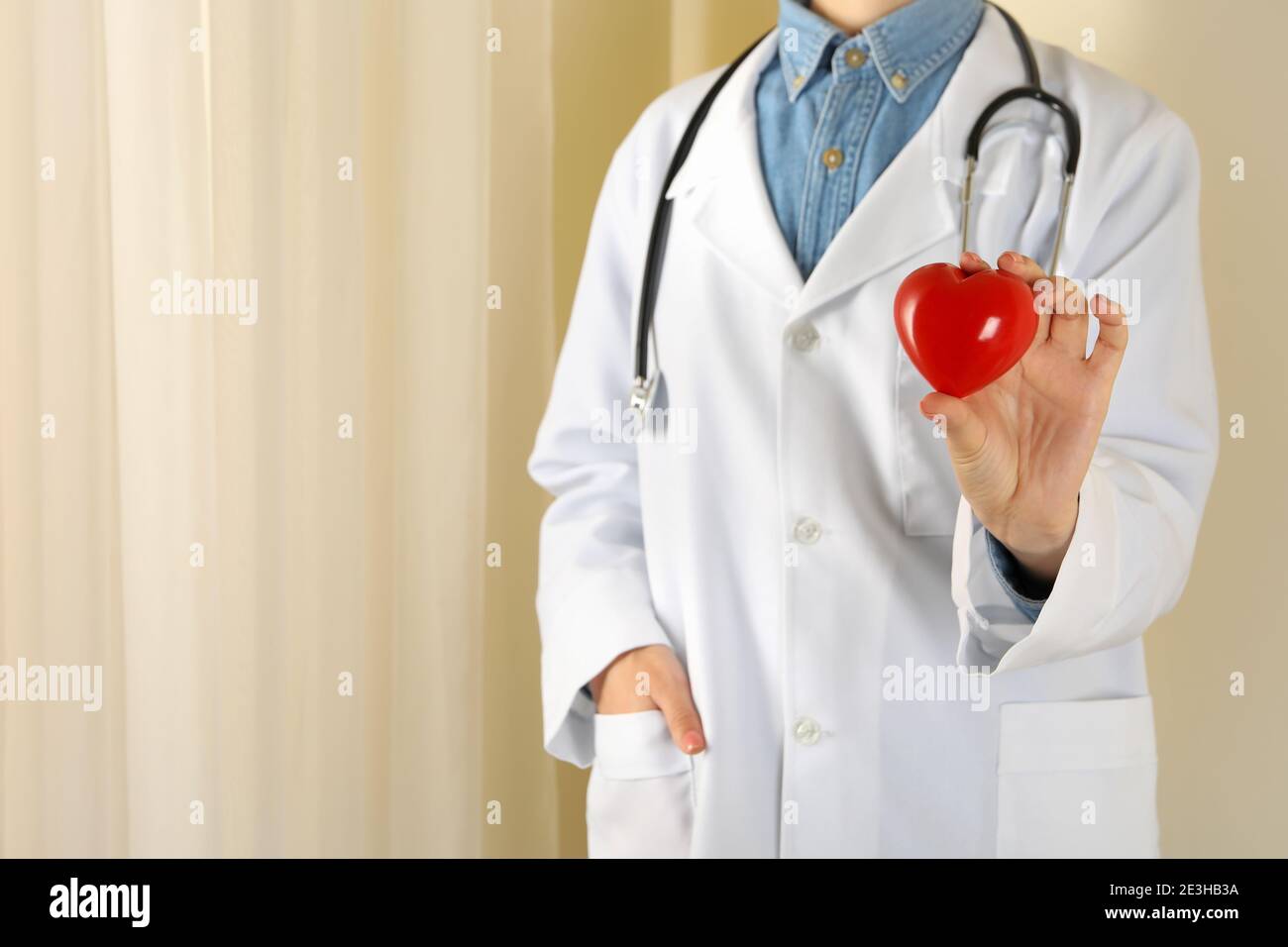 Female doctor with stethoscope holding red heart Stock Photo - Alamy