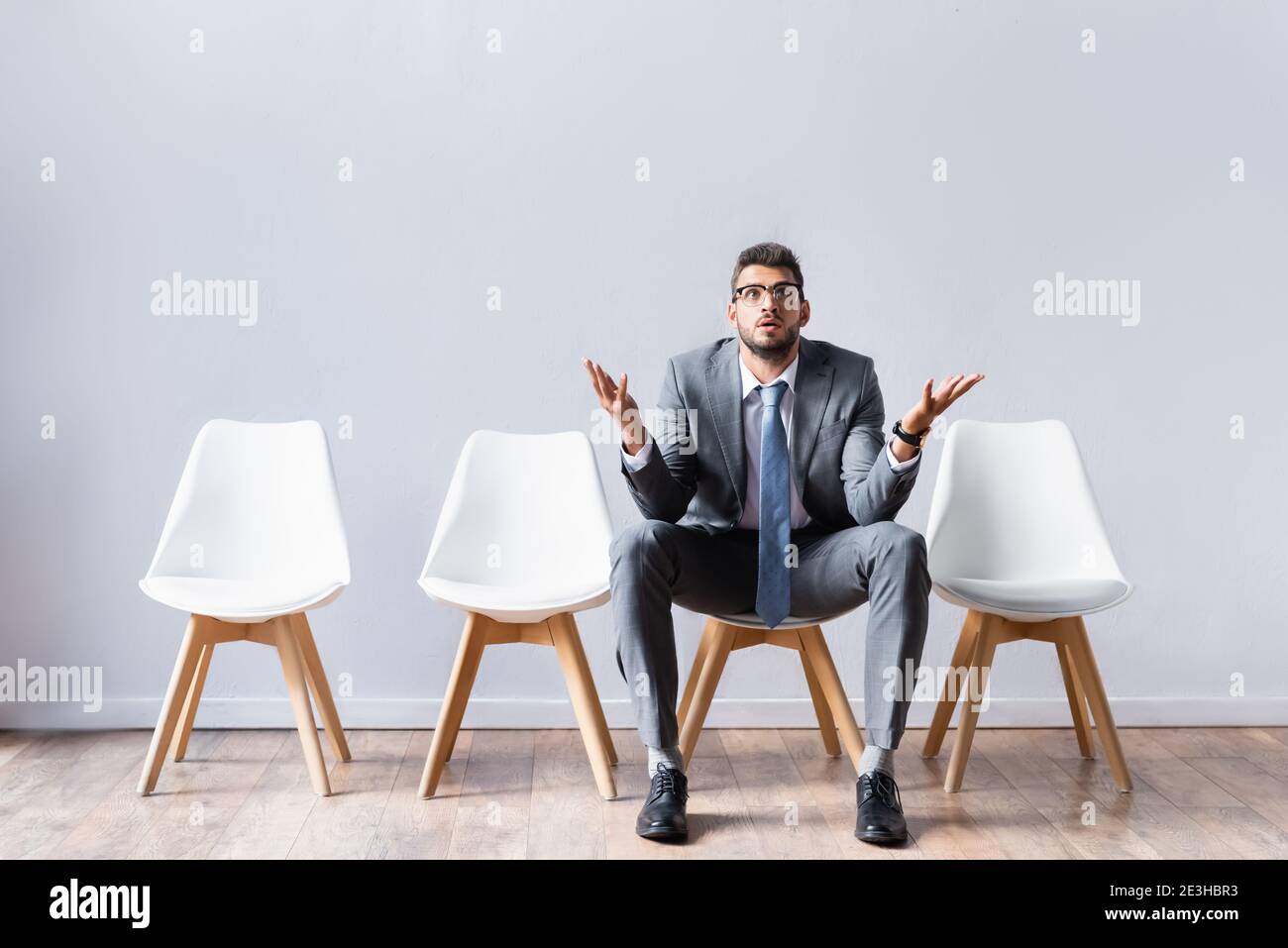 Businessman in suit pointing with hands while waiting job interview in office Stock Photo