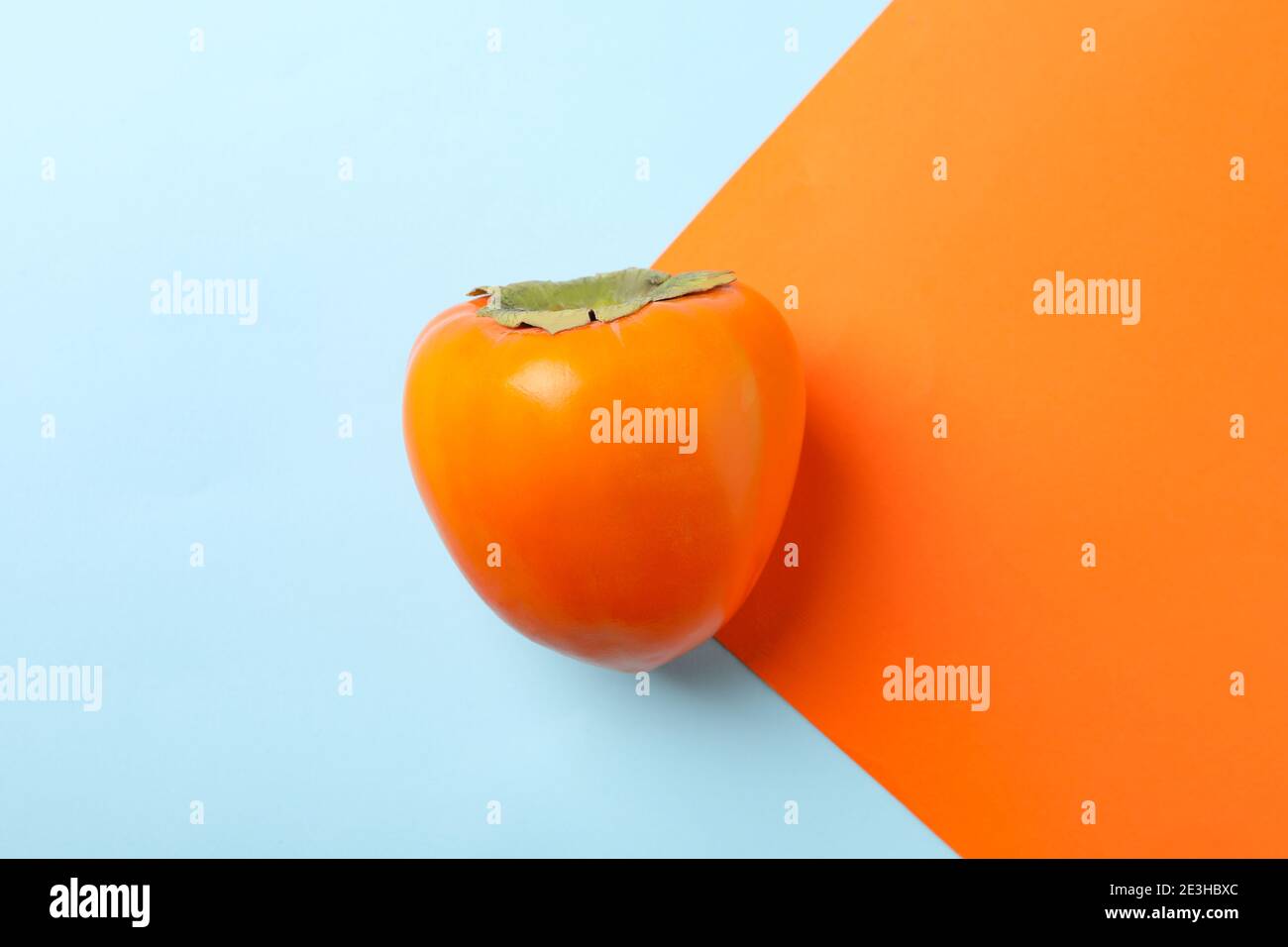 Fresh ripe persimmon on two tone background Stock Photo