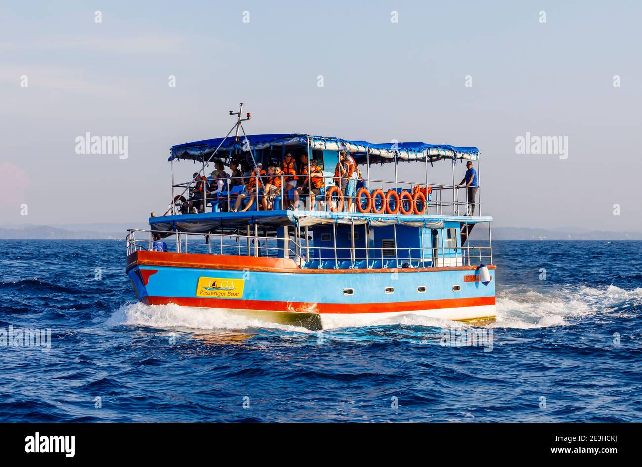 A blue tourist whale watching boat at sea with sightseers looking for blue whales and dolphins off Weligama, southern Sri Lanka Stock Photo