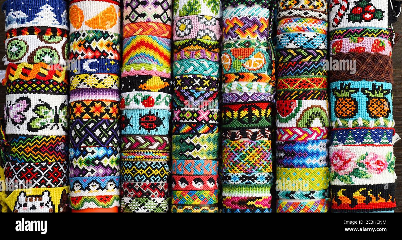 Many tied woven DIY friendship bracelets handmade of embroidery floss.  Alpha and normal patterns Stock Photo - Alamy