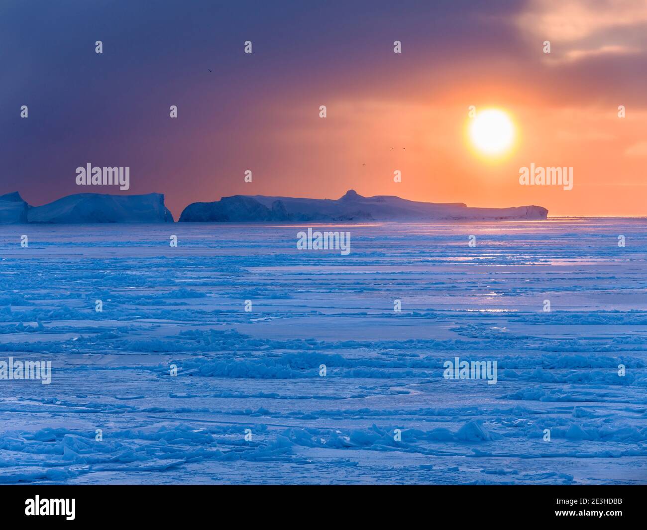 Sunset during winter at the Ilulissat Icefjord, located in the Disko ...