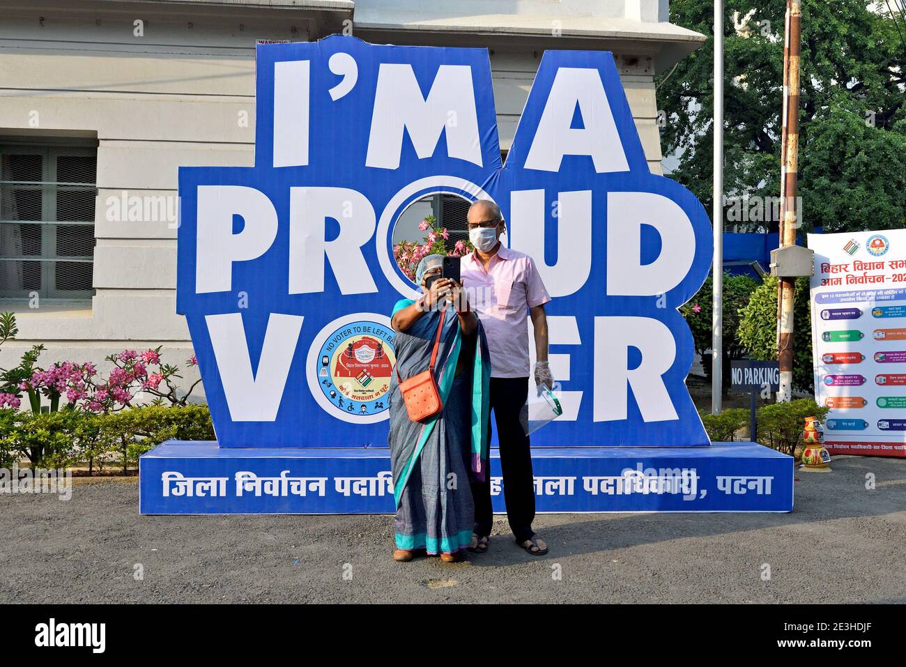 A man and a woman take a selfie outside the polling station after casting their vote in the state elections in Bihar. Stock Photo