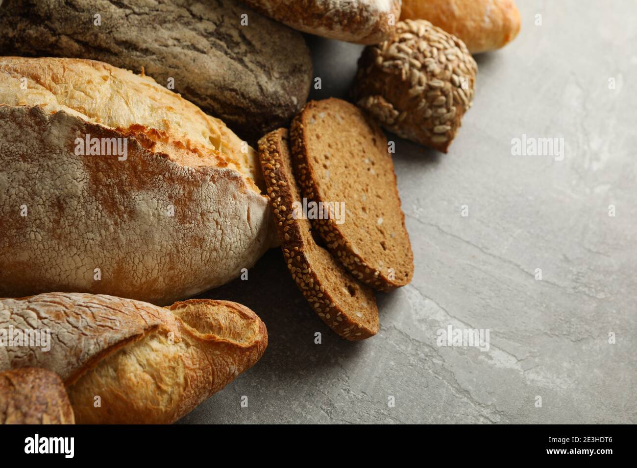 Different fresh baked bread on gray background Stock Photo - Alamy