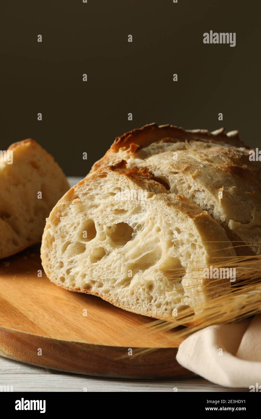 Board with fresh bread on white wooden background Stock Photo - Alamy