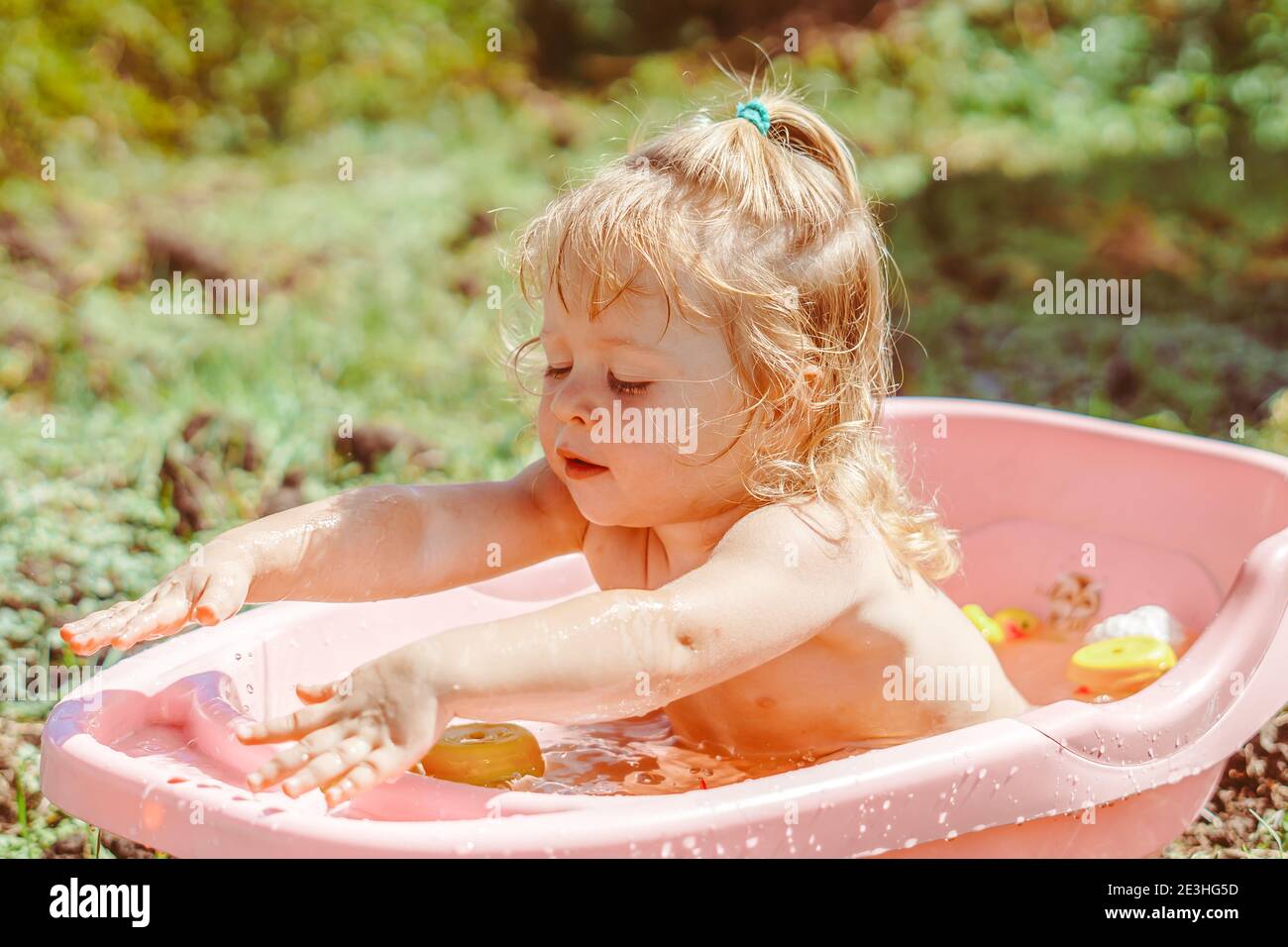 happy baby taking a bath outdoors in the garden Stock Photo Alamy
