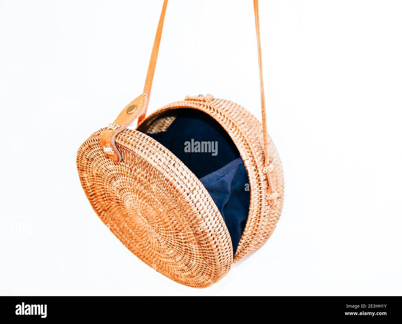 Opened round cross body rattan Ata bag with a leather strap and black lining Stock Photo