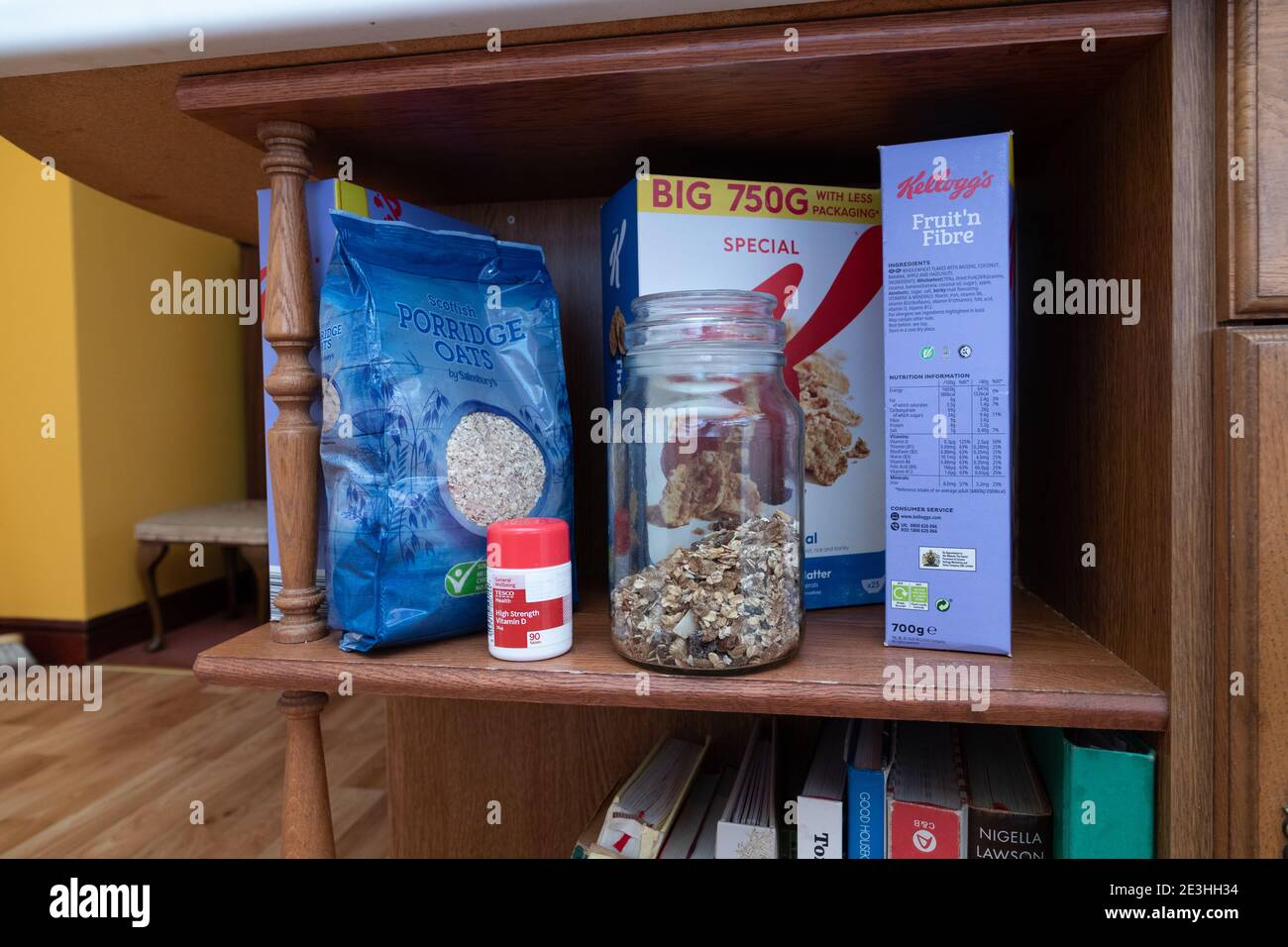 A row of breakfast cereals plus a bottle of Vitamin D pills on a shelf