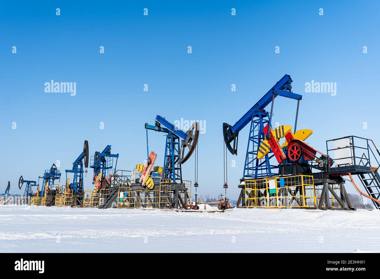 Oil and gas industry. Working oil pump jack on a oil field at winter sunny day. Oil production in Siberia. Stock Photo