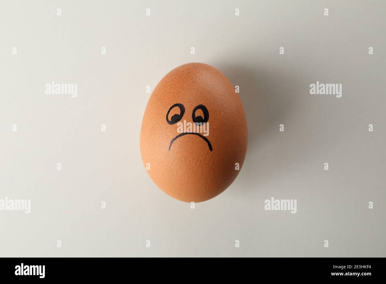 Boiled egg with sad face on white background Stock Photo