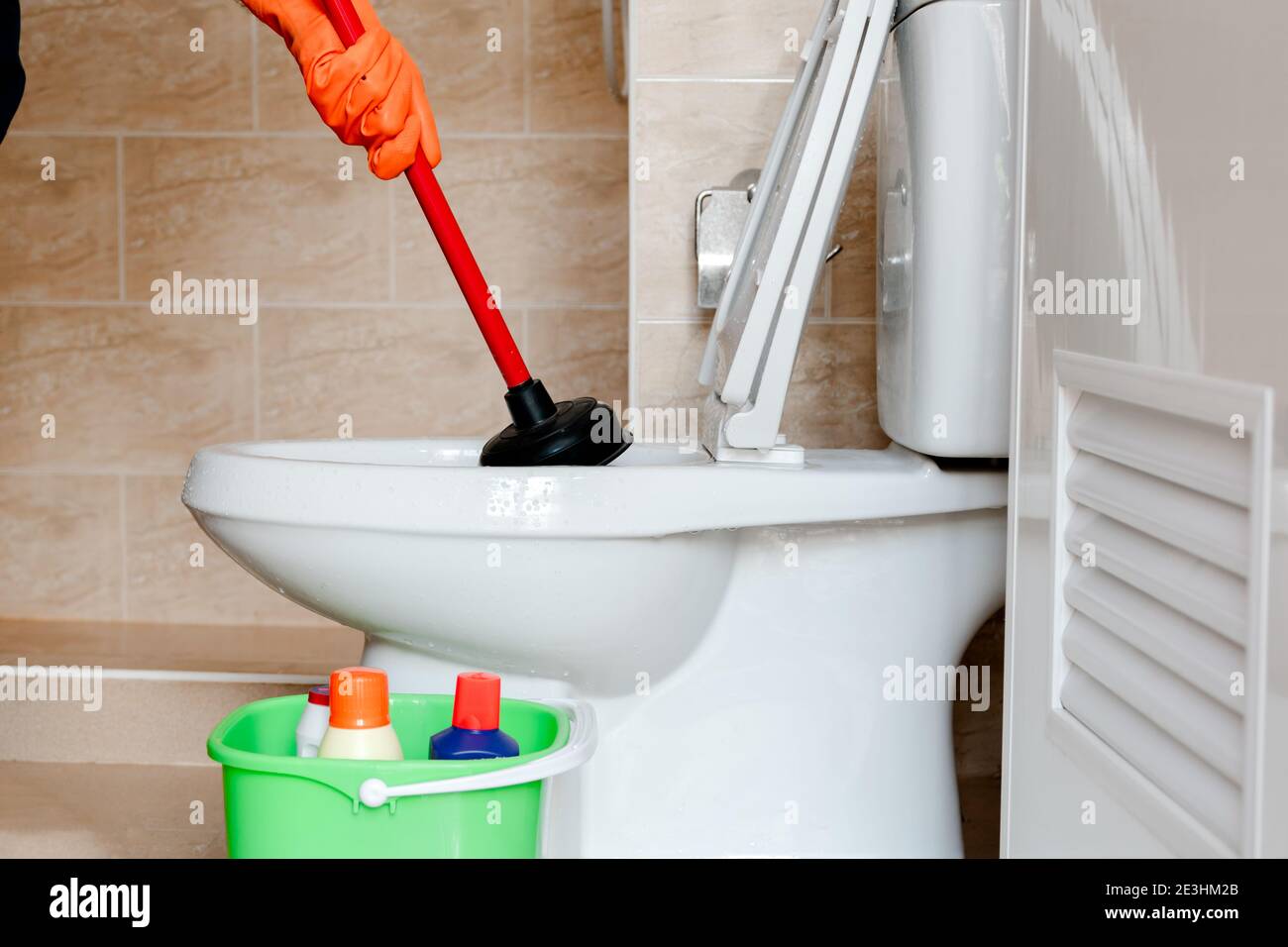 The man's hand is wearing a rubber glove cleaning the flush in the