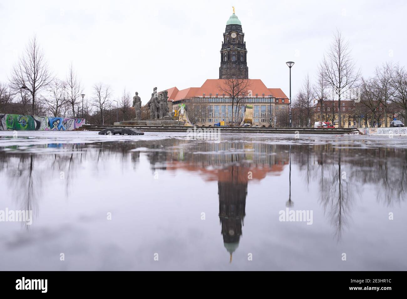 Dresden, Germany. 19th Jan, 2021. City Hall tower reflected in a puddle. Among other things, an extension of the lockdown until mid-February is being discussed as part of the upcoming federal and state Corona consultations. Credit: Sebastian Kahnert/dpa-Zentralbild/dpa/Alamy Live News Stock Photo