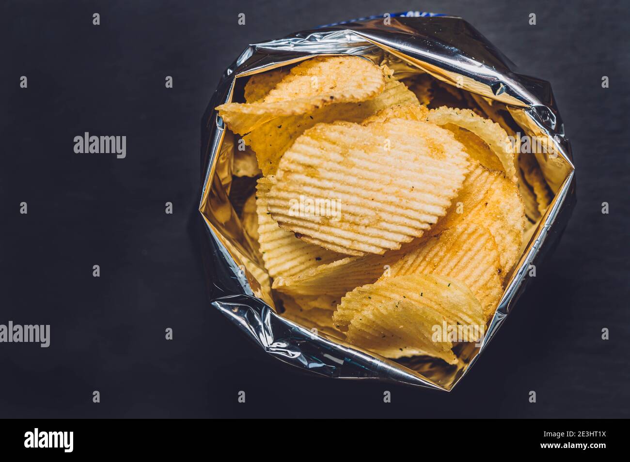 Close up top view of bag of chips or crisps isolated on black background.  Potato chips snack in bag ready to eat. Fast food or junk food Stock Photo  - Alamy