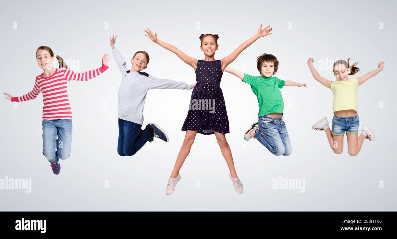 Cheerful Boys And Girls Jumping On Gray Studio Background, Collage Stock Photo