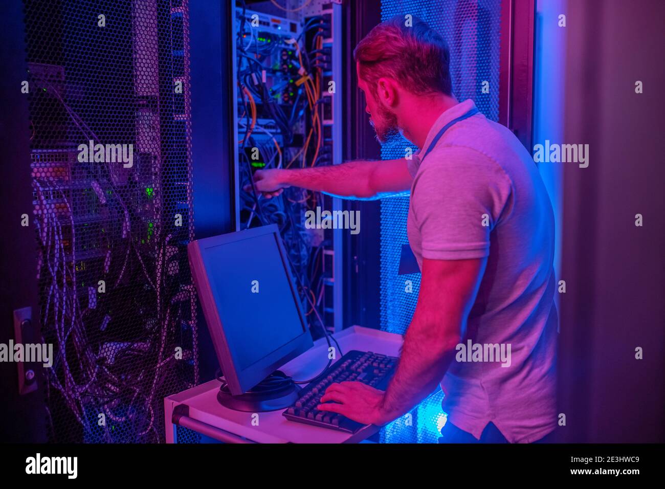 Male engineer in server room near computer Stock Photo