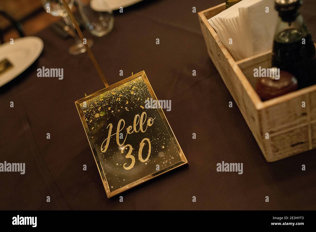 Invitation in gold and black to a 30th years birthday party framed in gold that reads 'Hello 30' set o pr Stock Photo