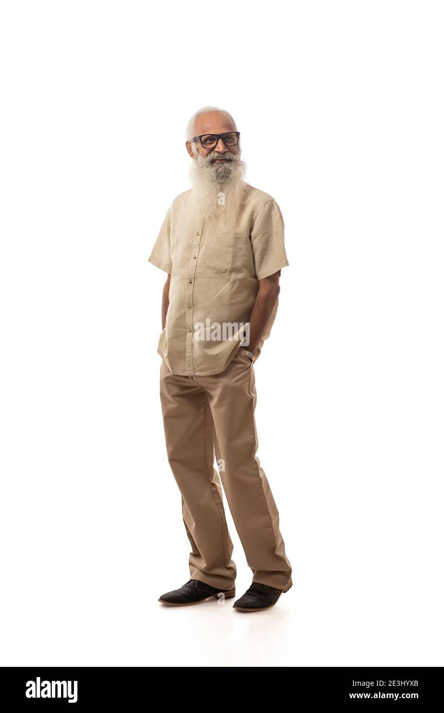 A BEARDED OLD MAN STANDING AND CHEERFULLY LOOKING AWAY Stock Photo