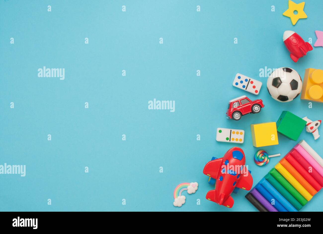 Frame of wooden and plastic kids toys on blue background with blank spce for text. Top view, flat lay. Stock Photo