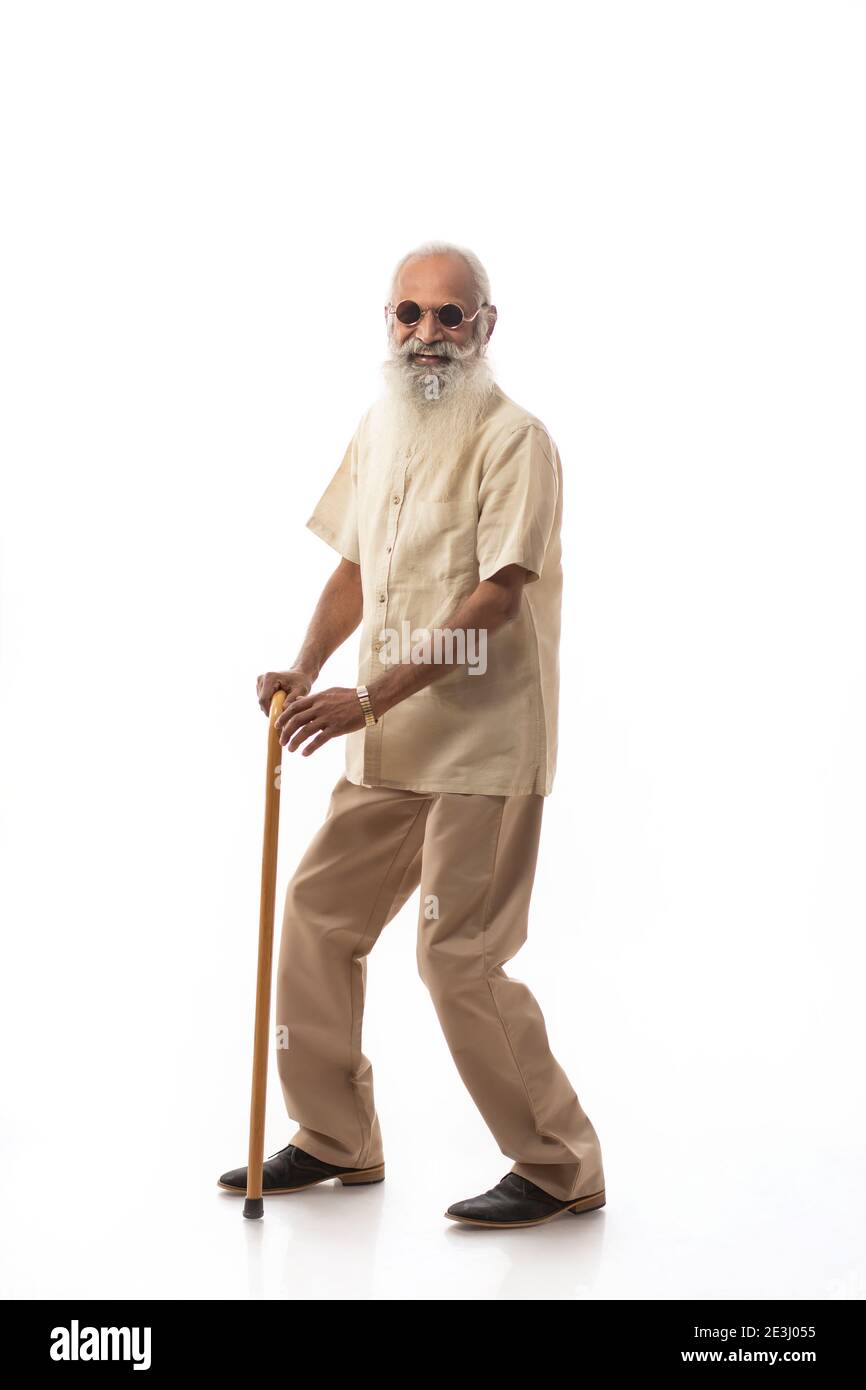 AN OLD MAN WEARING GOGGLES DANCING WITH STICK Stock Photo