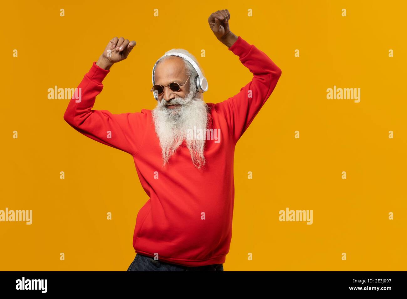 A STYLISH OLD MAN HAPPILY DANCING WHILE LISTENING TO MUSIC Stock Photo