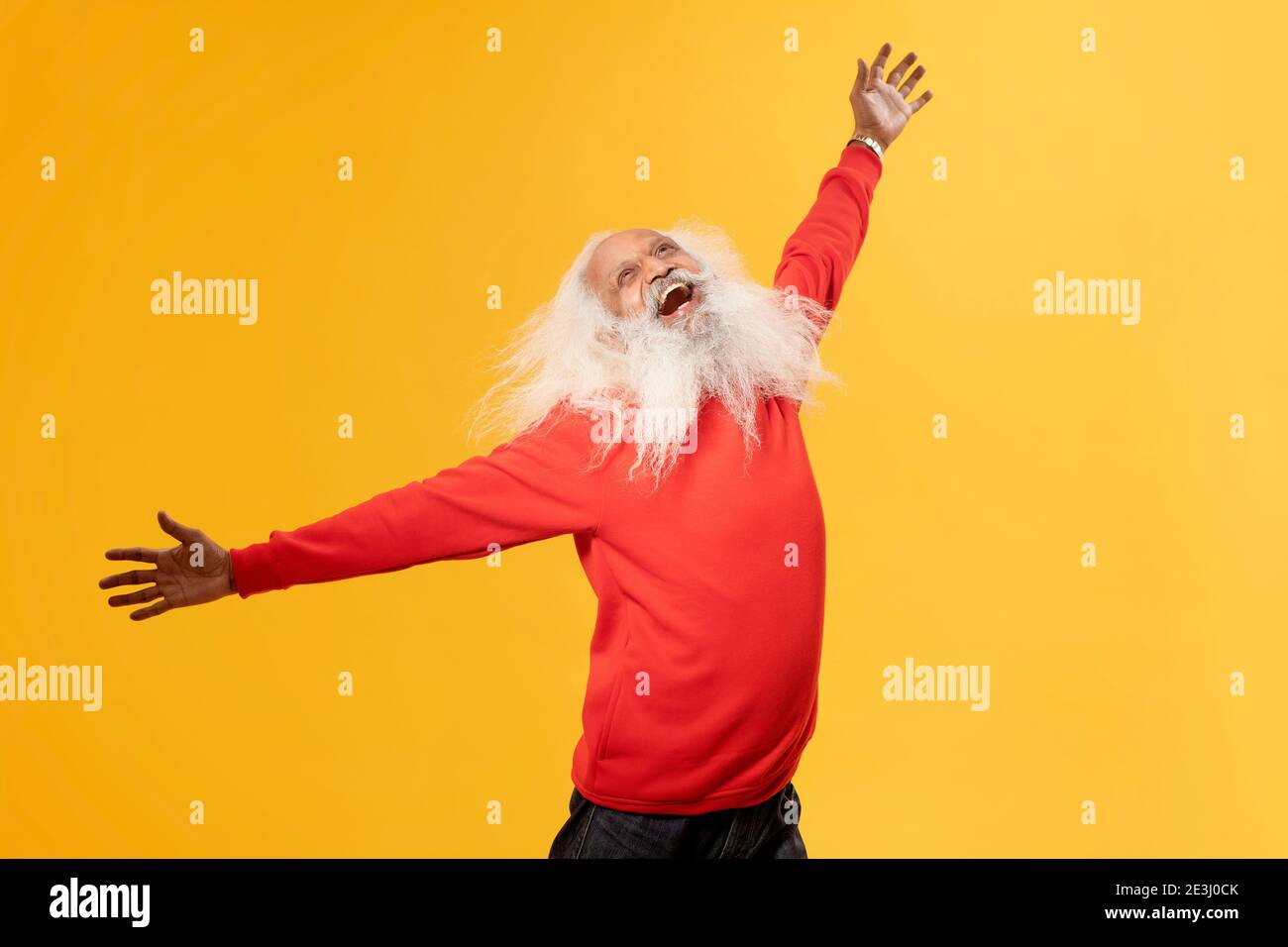 A CHEERFUL OLD MAN HAPPILY RAISING ARMS AND LOOKING ABOVE Stock Photo