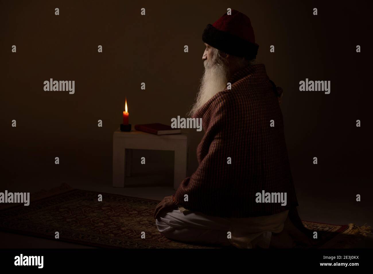 AN OLD MAN SITTING CALMLY AND PRAYING Stock Photo