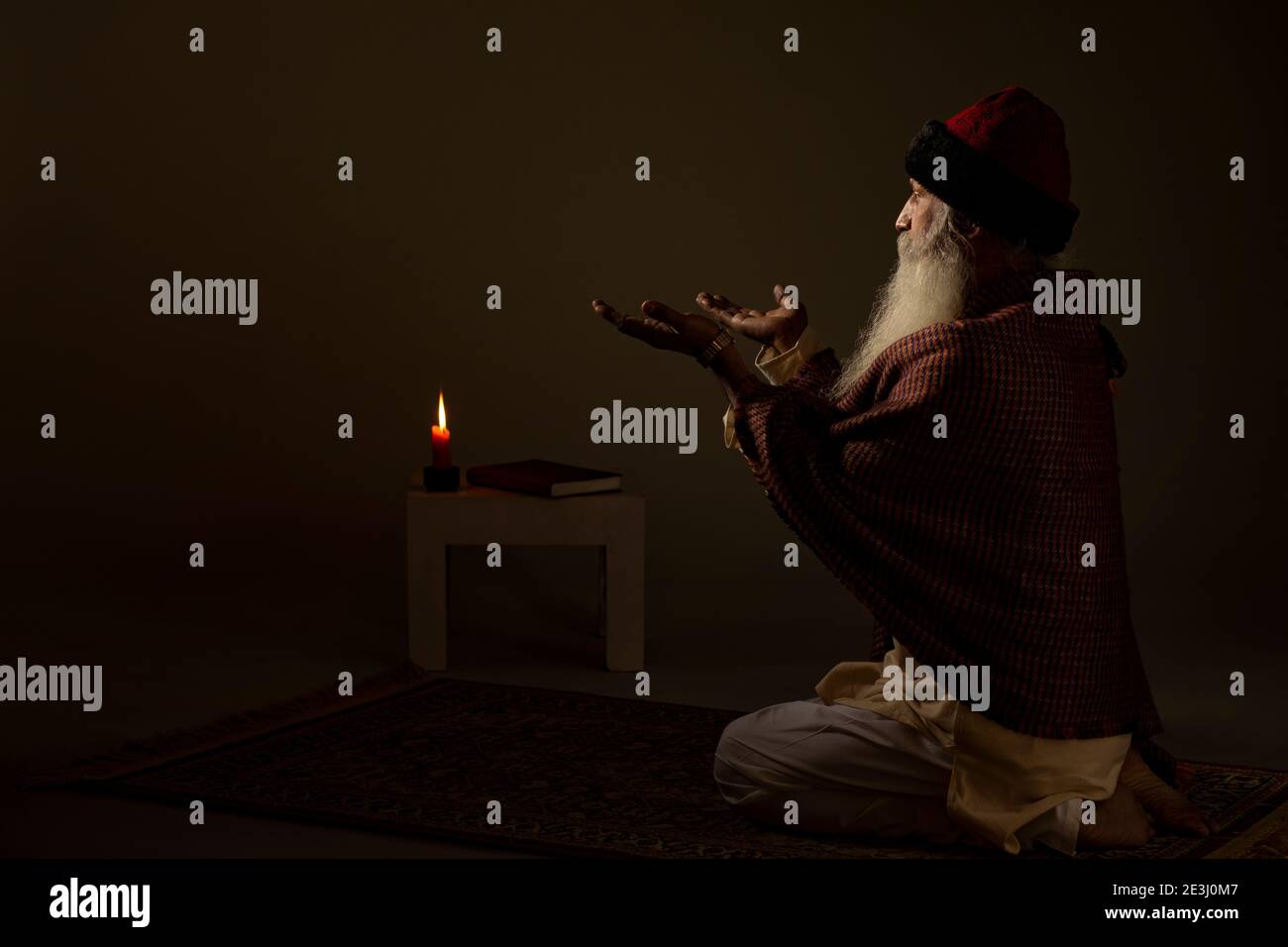 AN OLD MAN SITTING ALONE AND PRAYING Stock Photo