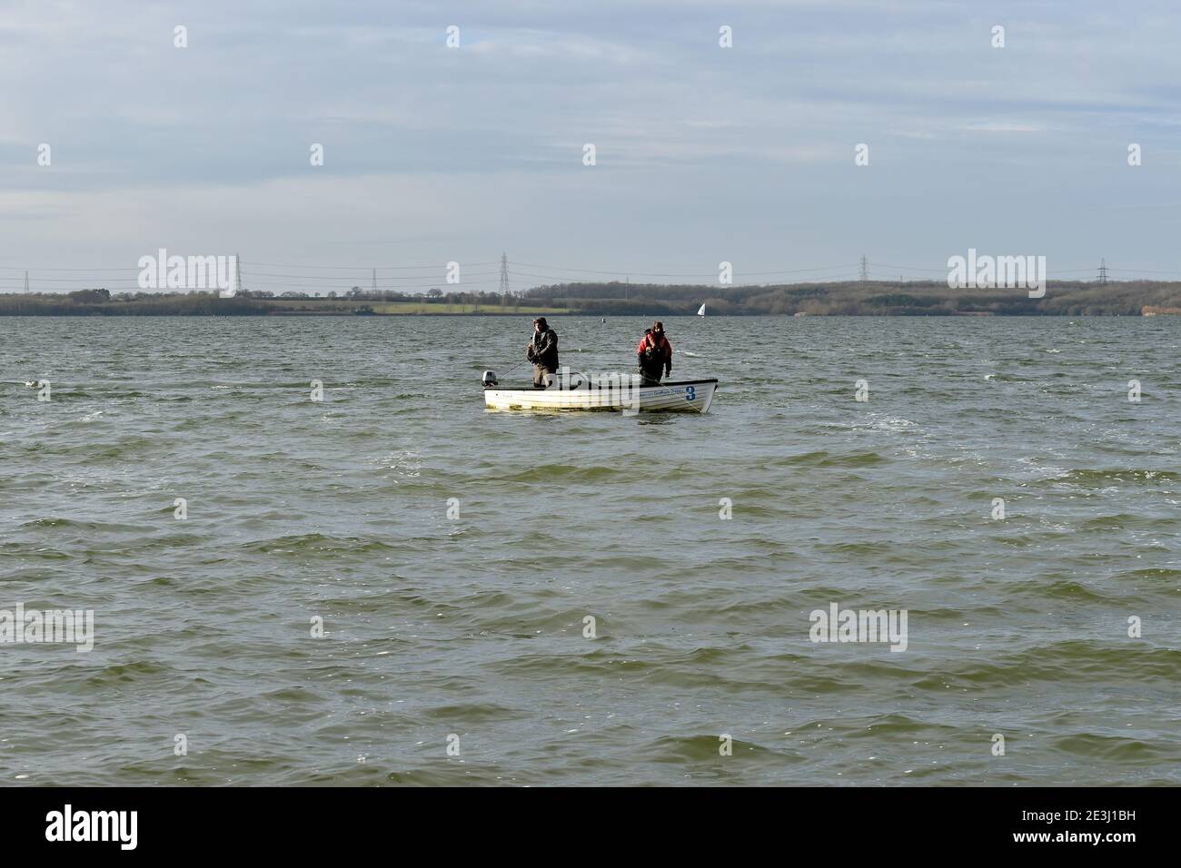 Two men fly fishing from a small boat on Anglian Water Grafham Reservoir in December. Stock Photo