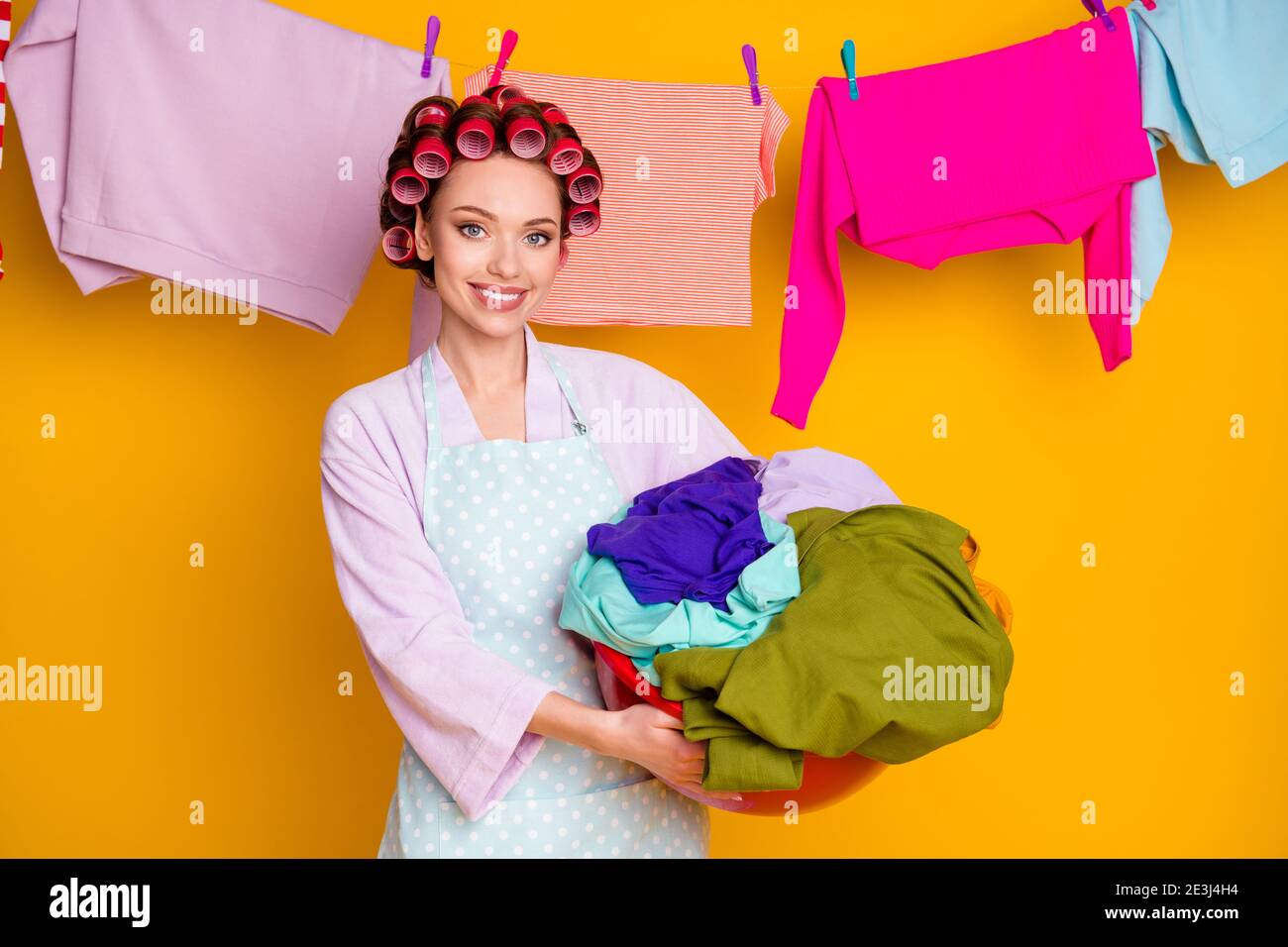 https://c8.alamy.com/comp/2E3J4H4/portrait-of-attractive-hardworking-cheerful-maid-holding-in-hand-dirty-wear-things-isolated-bright-orange-color-background-2E3J4H4.jpg
