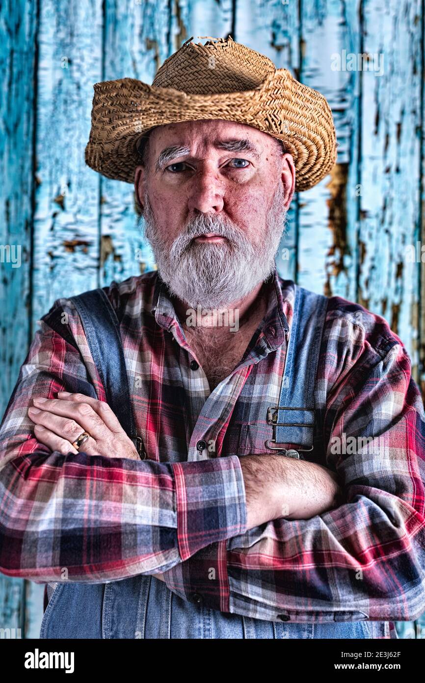 Elderly man in bib overalls. Post-processed for added drama. Stock Photo