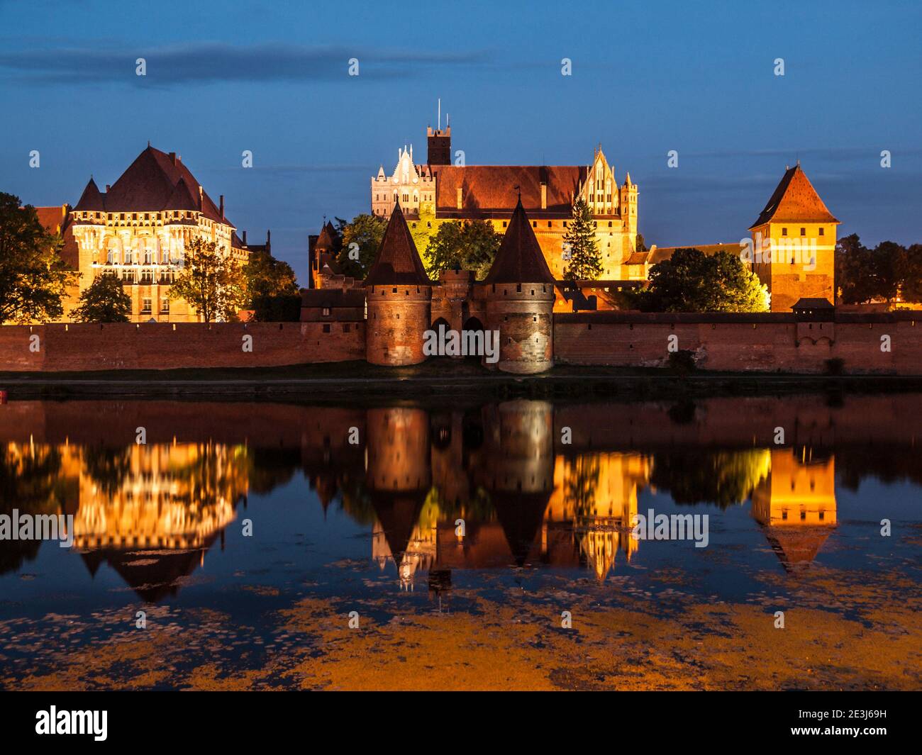 Malbork Castle by night with reflection in Nogat river, Poland Stock Photo