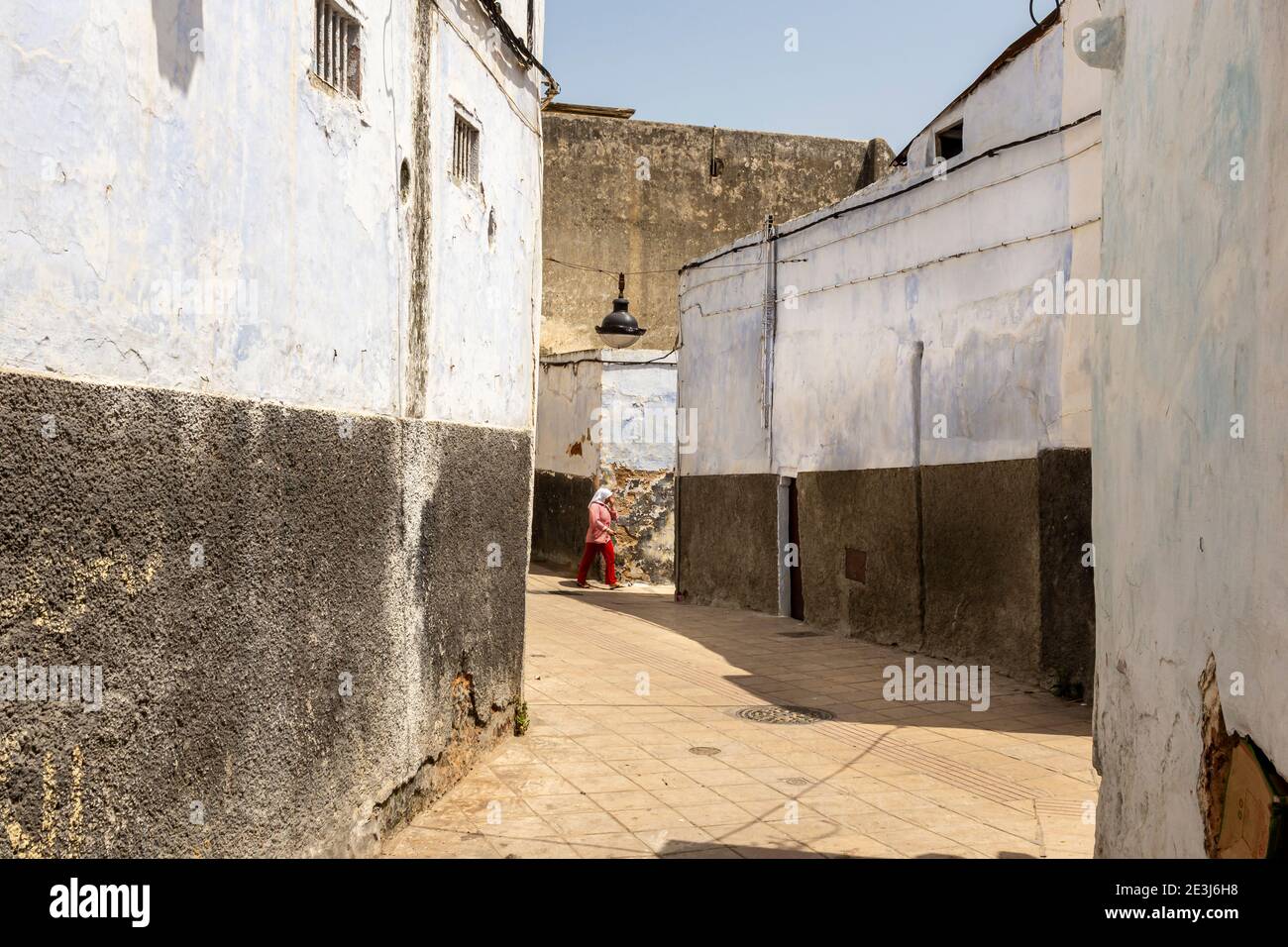 Woman walking through narrow street hi-res stock photography and images ...