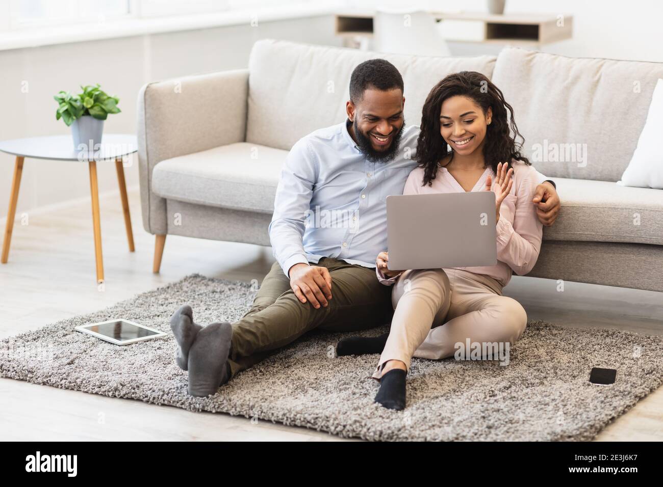 Black couple having videocall using laptop waving hands Stock Photo