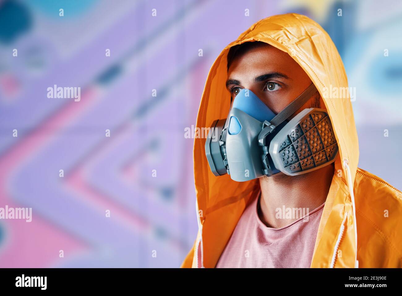 Graffiti painter in respirator mask standing near the wall with his  colorful paintings with copy space. Street art concept Stock Photo - Alamy