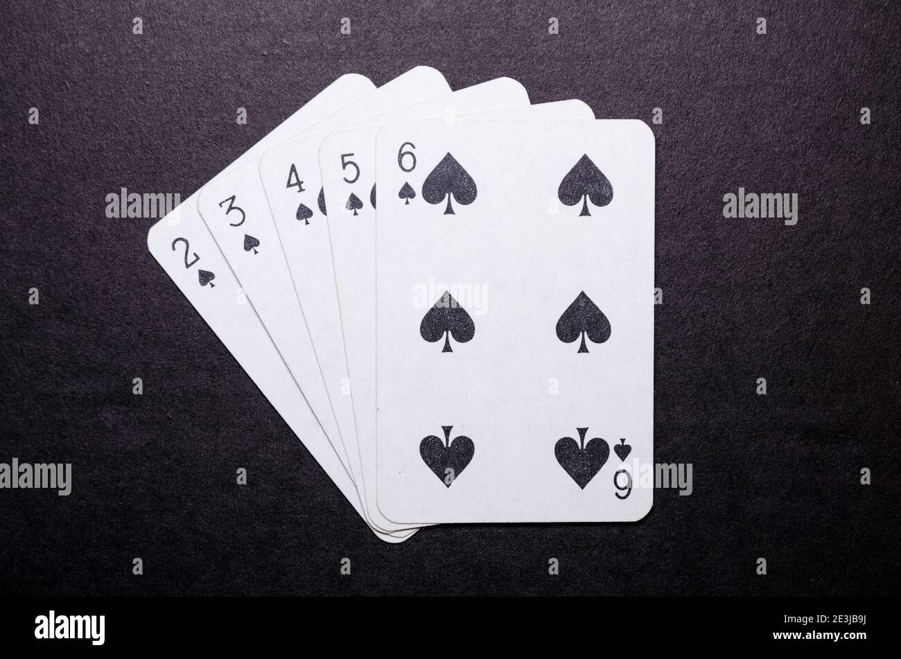 Playing cards on dark, black background, poker game hand, straight flush,  gambling concept, flat lay, view from directly above, top view Stock Photo  - Alamy