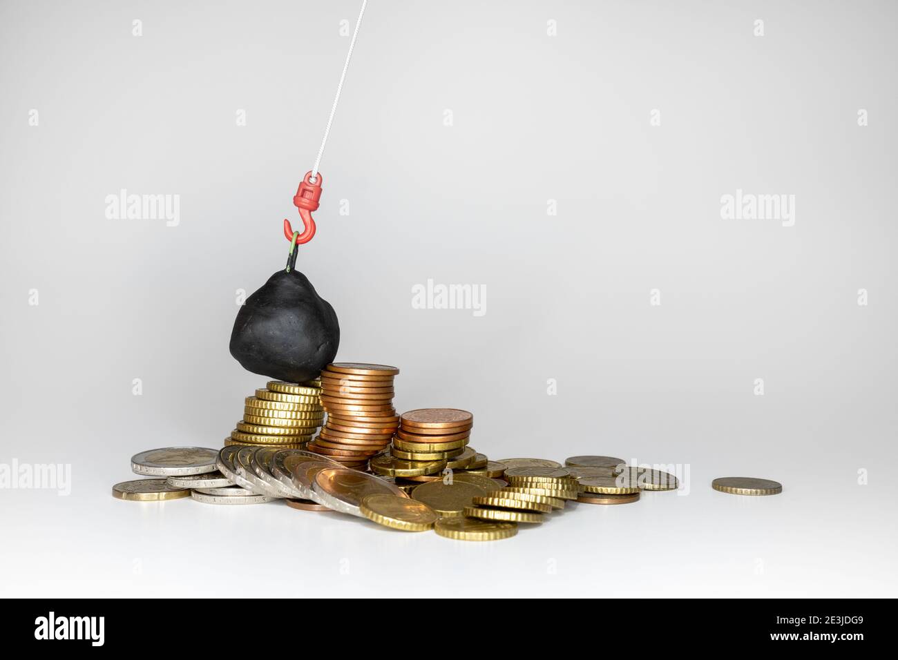 wrecking ball smashes stacked coin towers Stock Photo - Alamy