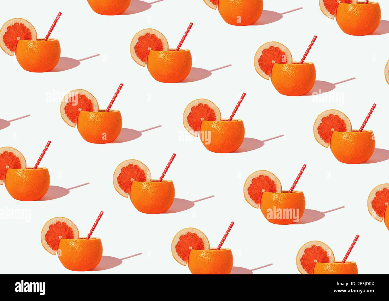 Creative pattern with  orange juice in the peel over white background .Minimal sunlit citrus layout.Isometric view. Stock Photo