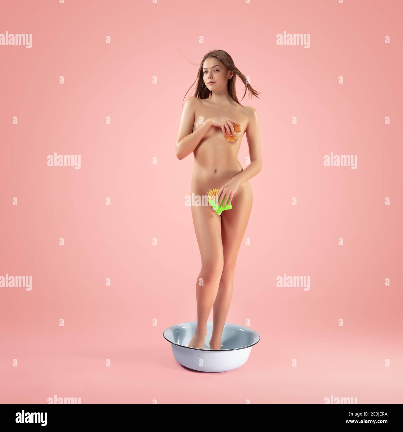 Fast food biting. Portrait of girl like modern remake of the Birth of Venus by Botticelli on pink background, copyspace. Comparison of eras, new look of classic paintings, artwork, inspiration concept. Stock Photo