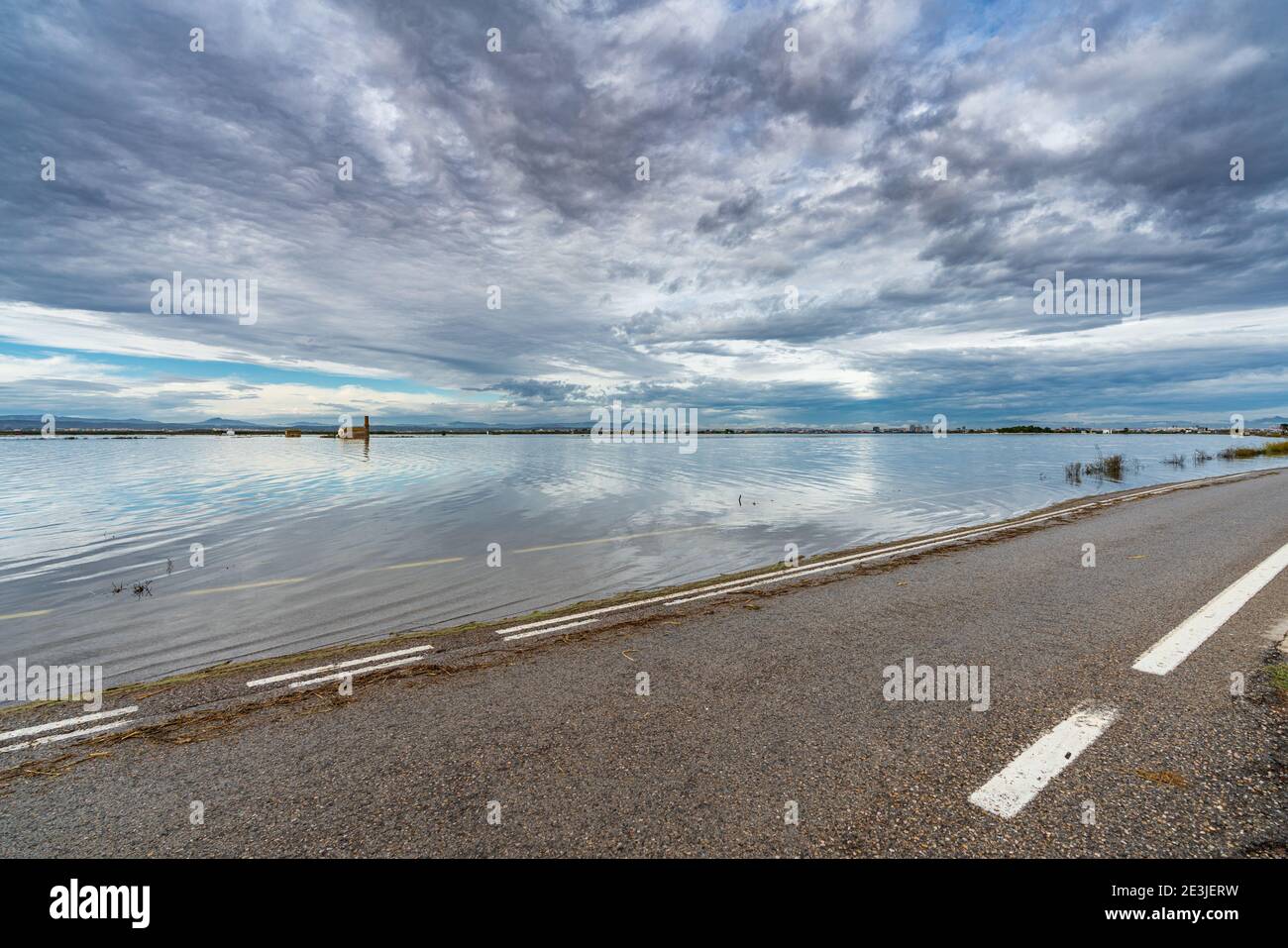 Flooded road under stormy and cloudy sky Stock Photo