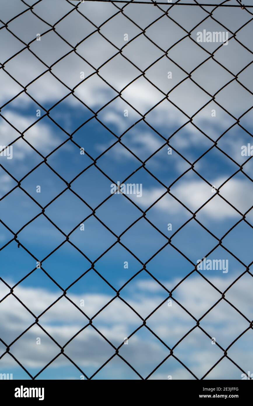 Chain link fence against a cloudy sky Stock Photo