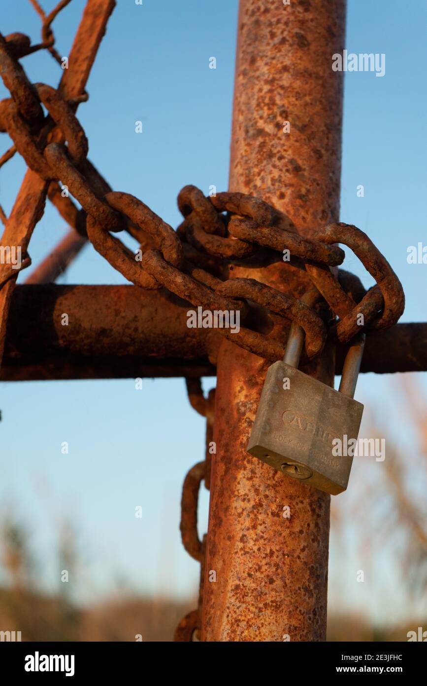 Rusty iron chain and lock closes iron gate Stock Photo