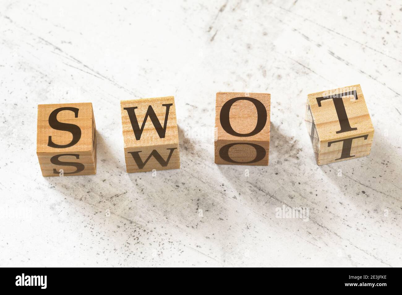 Four wooden cubes with letters SWOT (meaning Strength, Weakness