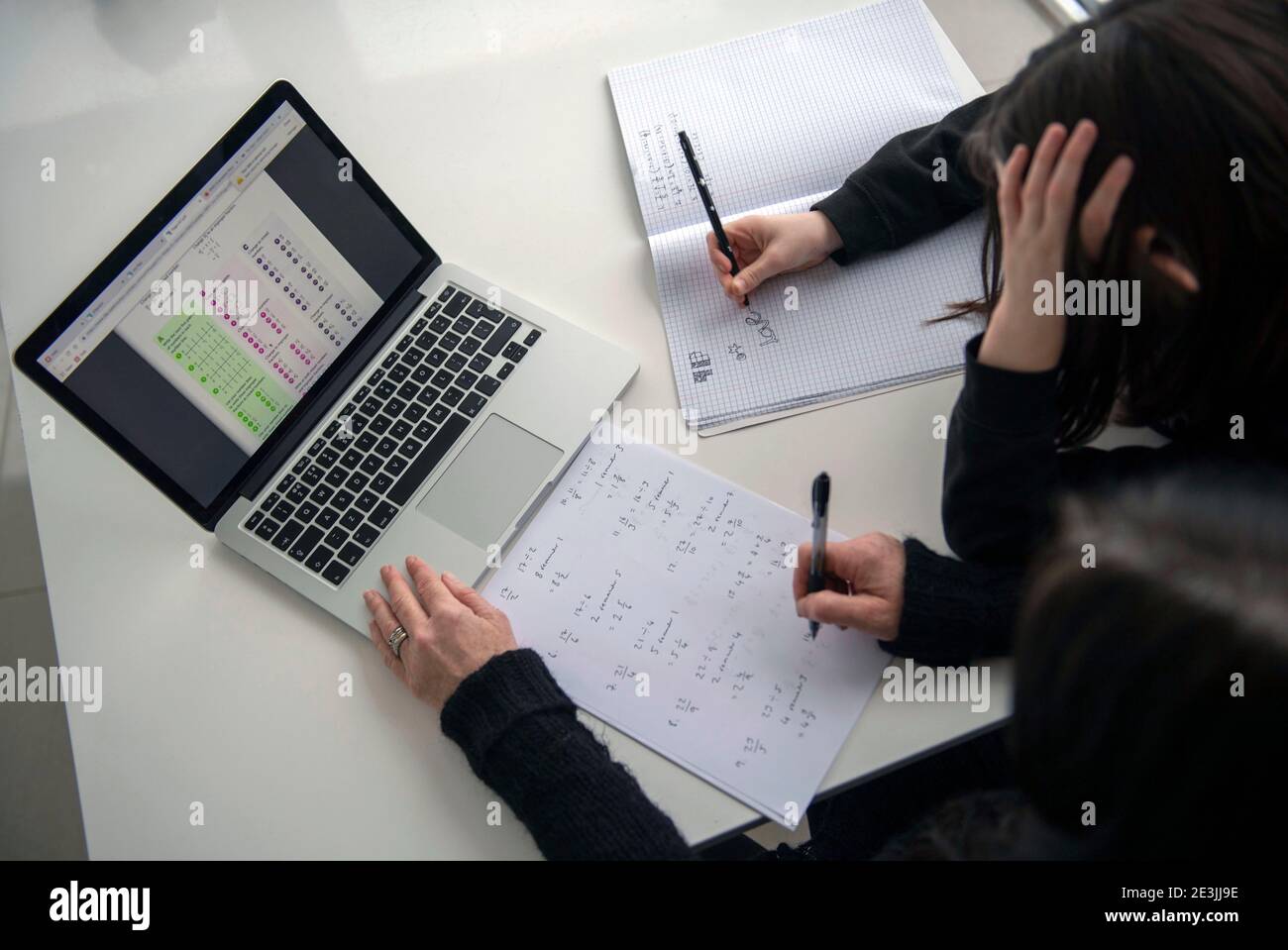 A child doodling while being home schooled with the help of a parent in the UK while both secondary and primary schools across the UK are still closed Stock Photo