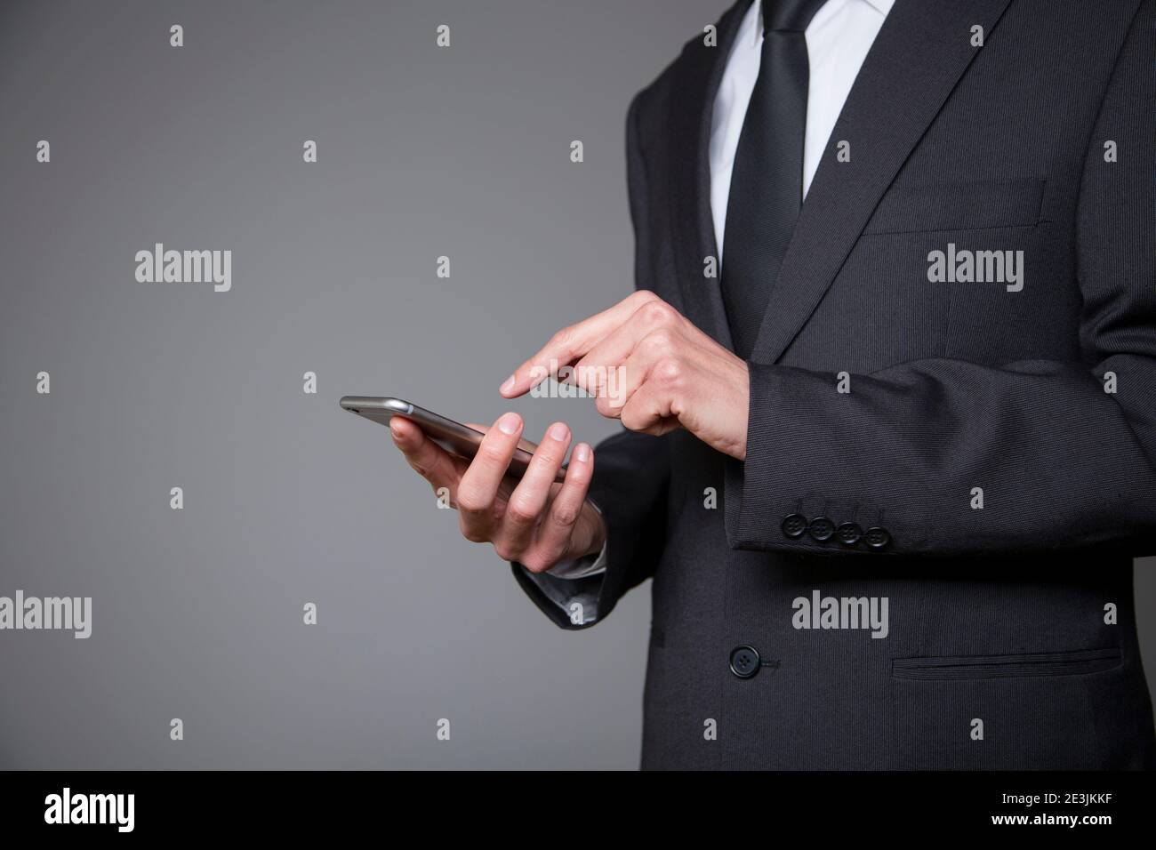 businessman wearing black suit using mobile phone Stock Photo - Alamy