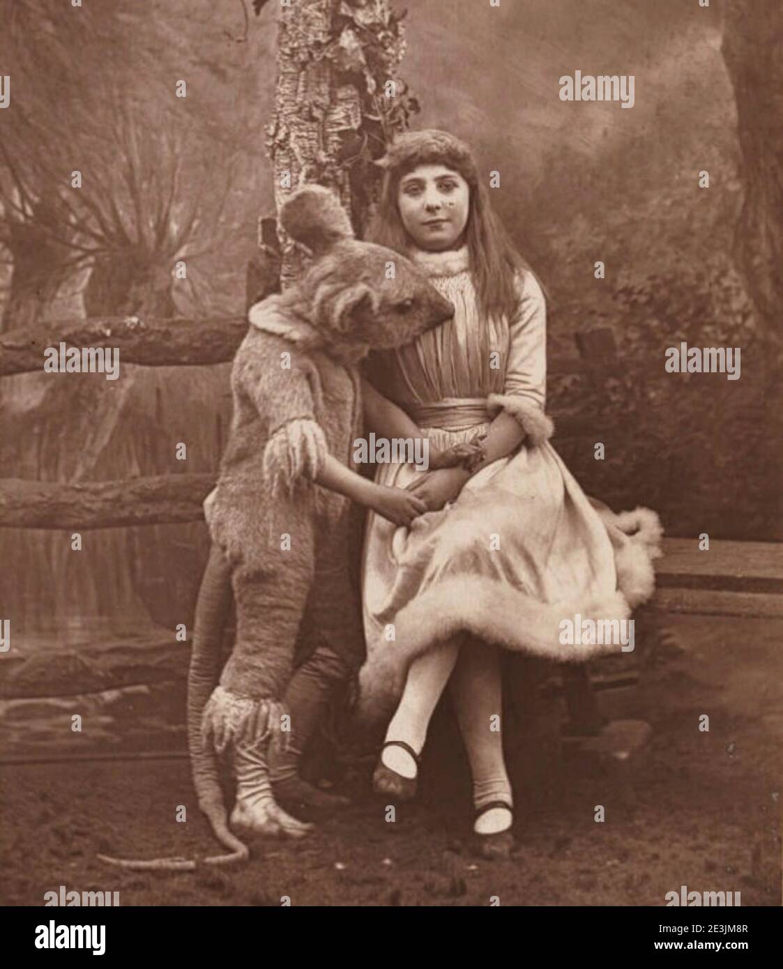 Phoebe Carlo as Alice in the pantomime Alice in Wonderland by the portrait photographer Herbert Rose Barraud. Alice poses with the dormouse on stage. Stock Photo