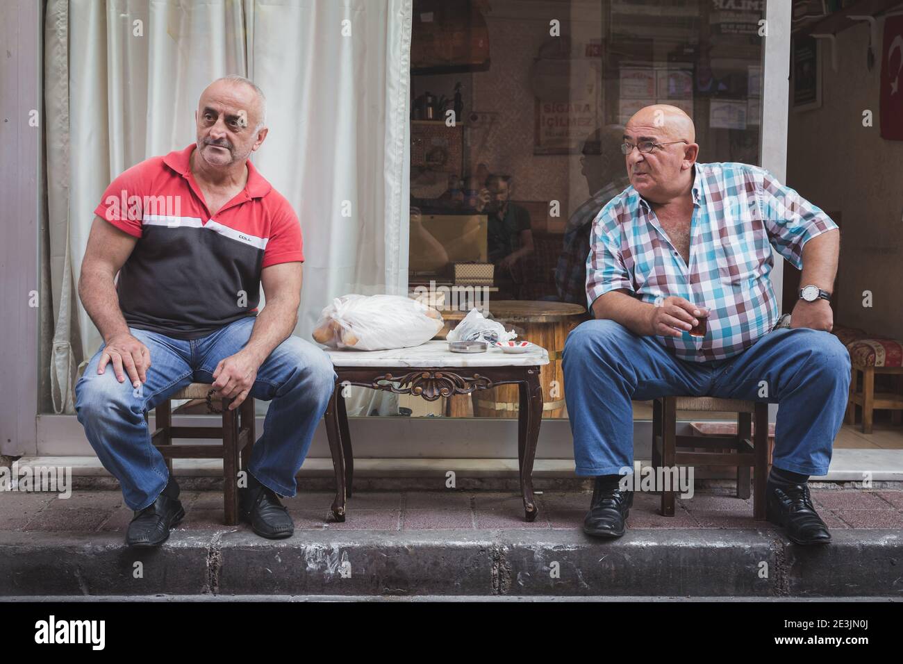 Istanbul, Turkey - September 17 2017: 2 local Turkish men socialising and drinking tea on the streets of the multicultural and authentic Istanbul neig Stock Photo
