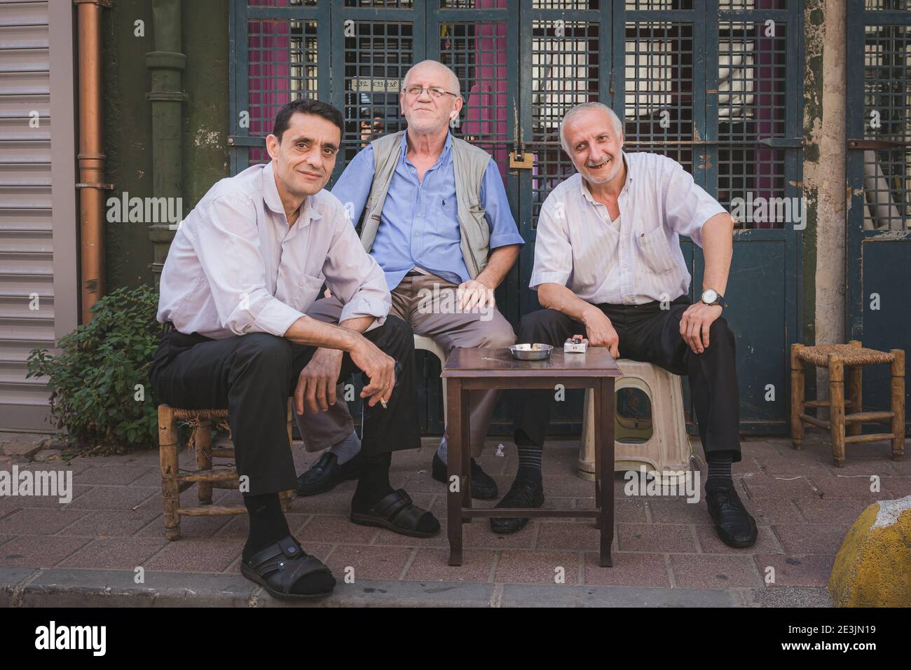 Istanbul, Turkey - September 17 2017: 3 local Turkish men socialising and smoking on the streets of the cultural and authentic Istanbul neighbourhood Stock Photo