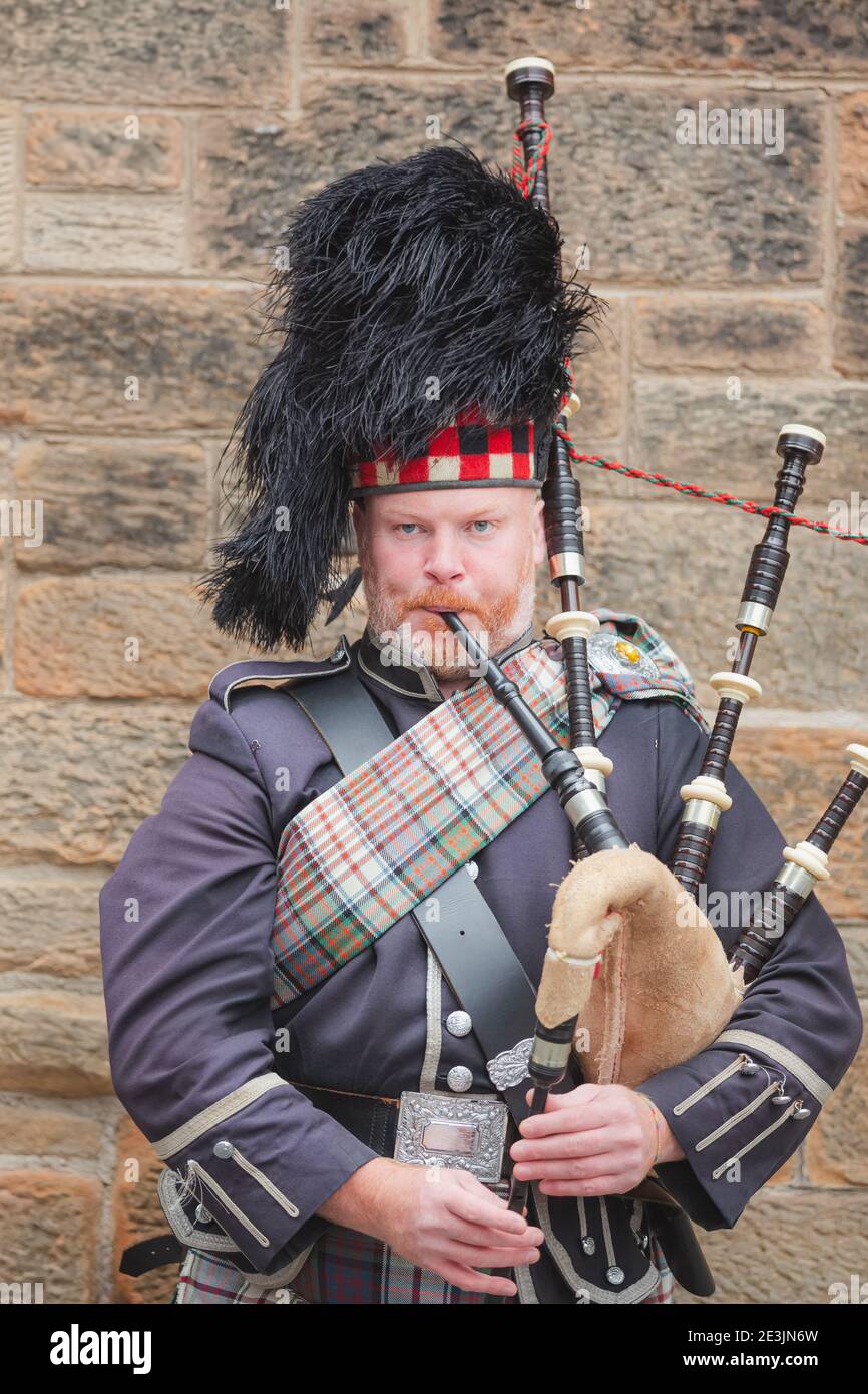 Edinburgh, Scotland - August 6 2017: A Scottish bagpiper performs along the Royal Mile in Edinburgh Old Town during the Fringe Festival. Stock Photo